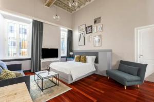 a living room with a bed and a couch and a chair at Croce Apartments in Rome