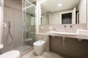 a bathroom with a toilet and a sink and a shower at Croce Apartments in Rome