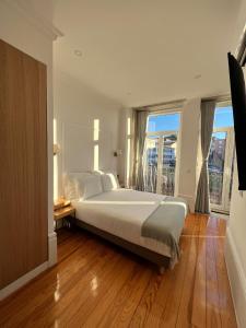 een slaapkamer met een groot bed en een groot raam bij Oportoflag center in Porto +42 foto's