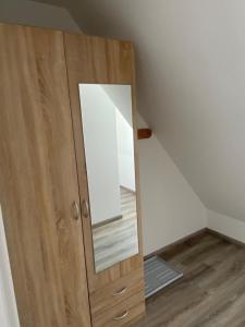 a wooden cabinet with a mirror on top of it at Hotel Braunlage in Braunlage