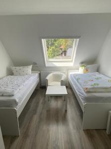 ブラウンラーゲにあるHotel Braunlageのベッド2台と窓が備わる小さな客室です。