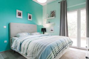 Dormitorio azul con cama y ventana en Lux Beach Apartment, en Vari