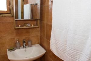 baño con lavabo y cortina de ducha blanca en Villa Argyro Triopetra, en Triopetra