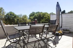 una mesa y sillas en un patio con sombrilla en Charming Flat with a Lovely Terrace in Yenikoy, en Estambul