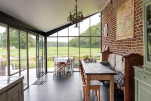 a dining room with a brick wall and a table at B&B De Paenhoeve in Eksel