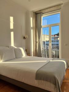 a bedroom with a large bed and a large window at Oportoflag center in Porto