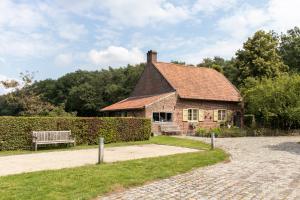 a brick house with a bench in front of it at B&B De Paenhoeve in Eksel