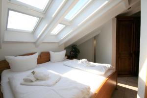 フュッセンにあるFerienwohnung Neuschwansteinのベッドルーム1室(白いシーツと天窓付きのベッド2台付)