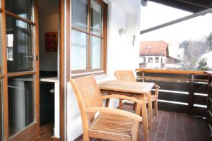 a wooden table and chairs on a balcony at Ferienwohnung Steuer in Füssen