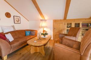 sala de estar con sofá, 2 sillas y mesa en Alpenliebe en Alterschrofen