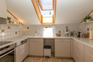 una cucina con armadietti bianchi e una finestra di Alpenliebe a Alterschrofen Altre 10 foto