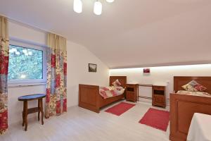 Schlafzimmer mit einem Bett, einem Schreibtisch und einem Fenster in der Unterkunft Ferienwohnung Landhaus Helga unterm Schloss in Schwangau
