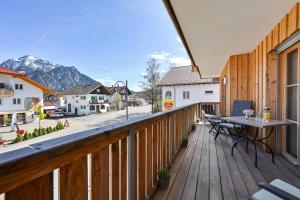 a wooden balcony with a table and a view of the mountains at Ferienwohnung Mibba din in Schwangau