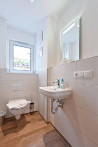 プフロンテンにあるMonusse Boid Wohnung 6の洗面台とトイレを備えた白いバスルーム +11枚の写真