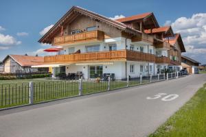 a house with a balcony on the side of a road at Landhaus am See Appartement LH 1 in Schwangau