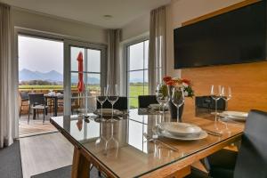 a dining room with a table with wine glasses at Landhaus am See Appartement LH 1 in Schwangau