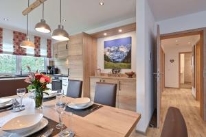 a kitchen and dining room with a table and chairs at Monusse Boid Wohnung 11 in Pfronten