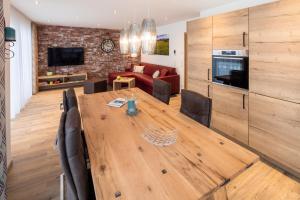 uma sala de jantar com uma mesa de madeira e uma sala de estar em Monusse Boid Wohnung 13 em Pfronten