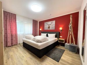 a bedroom with a large bed with a red wall at Monusse Boid Wohnung 8 in Pfronten