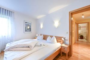 Un dormitorio con una gran cama blanca con almohadas blancas. en Ferienwohnung Am Kienberg, en Pfronten