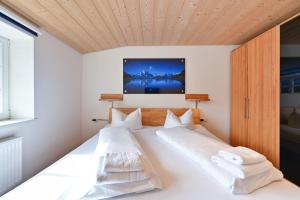 two beds in a bedroom with a wooden ceiling at Ferienwohnung Rommel in Pfronten