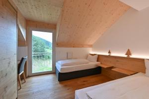 a bedroom with two beds and a large window at Ferienwohnung Zugspitze in Pfronten