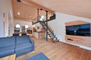 a living room with a blue couch and a staircase at Ferienwohnung Zugspitze in Pfronten