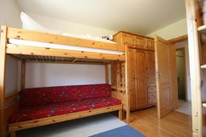 a bunk bed with a red couch in a room at Ferienwohnung Romi in Pfronten