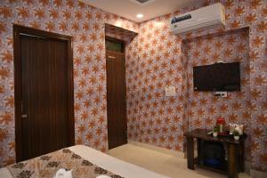 a hotel room with a tv on a wall at Hotel Shine Star By Tag Your Trip Near Golden Temple in Amritsar
