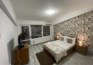 1 dormitorio con 1 cama y TV en Hotel Rivoli, en Bucarest