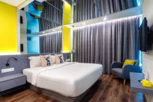 a hotel room with a bed and a chair at Apple Hotel Times Square in George Town