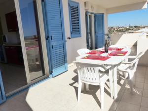 a white dining table and chairs on a balcony at siciliacasevacanze - Ulivi in Marina di Ragusa