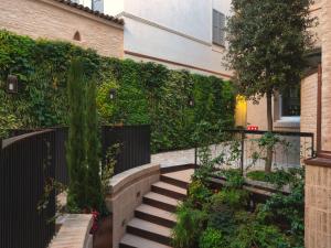 un jardín con escaleras y un seto verde en Bellacorte Gentiluogo per Viaggiatori, en Parma