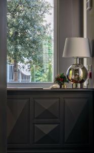 una lampada seduta su un comò accanto a una finestra di Bellacorte Gentiluogo per Viaggiatori a Parma