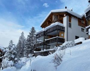 a building in the snow with snow covered trees at Just 10min from Lenzerheide - Apartment in Vazerol in Brienz-Brinzauls