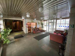 a lobby with couches and chairs in a building at Riverside Motel Jelgava in Jelgava