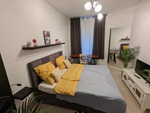 - une chambre avec un lit et des oreillers jaunes dans l'établissement Schönes Apartment im Zentrum von Koblenz, à Coblence