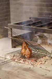a piece of meat is cooking on a grill at Country Hotel Residence Da Pilade in Capoliveri