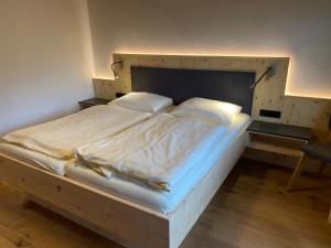 a large bed with a wooden frame in a bedroom at Gasthof Mühle in Wattens