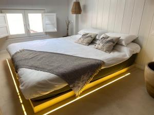 a bed in a bedroom with a lighted bed frame at Charming loft in the heart of El Carmen Valencia in Valencia