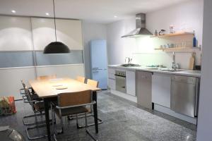 a kitchen with a wooden table and a dining room at LIVING .... Bungalow mit großem Garten . in Halver