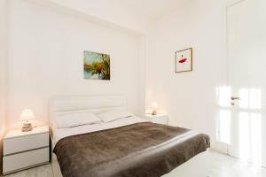 una camera bianca con un letto e due comodini di Luxury Landing III a Tbilisi City