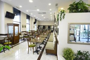 un comedor con mesas, sillas y plantas en Luxury Landing III en Tiflis