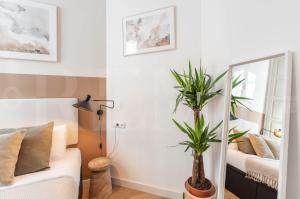 salon z lustrem i kanapą w obiekcie Artistic apartment in the heart of Málaga by REMS w Maladze