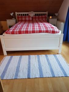 um quarto com uma cama com um cobertor vermelho e branco em Ferienwohnung Am Mühlbach 2 em Halblech