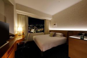 a hotel room with a bed and a window at Hotel Nikko Kanazawa in Kanazawa