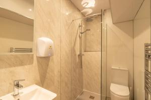 a bathroom with a shower and a sink and a toilet at Lakes Boutique Hostel Apartment Windermere in Windermere +37 photos