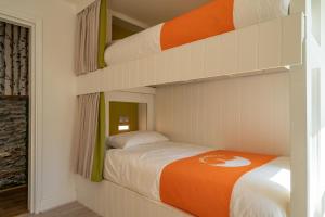 a bedroom with a bunk bed with an orange blanket at Lakes Boutique Hostel Apartment Windermere in Windermere