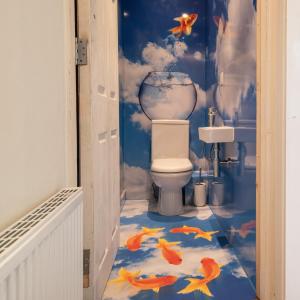 a bathroom with a toilet with fish painted on the floor at Lakes Boutique Hostel Apartment Windermere in Windermere
