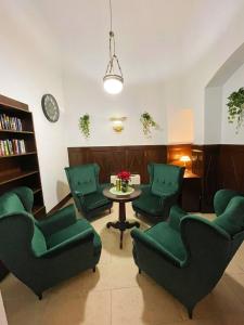 a living room with green chairs and a table at Great Polonia Kraków Old Town in Krakow